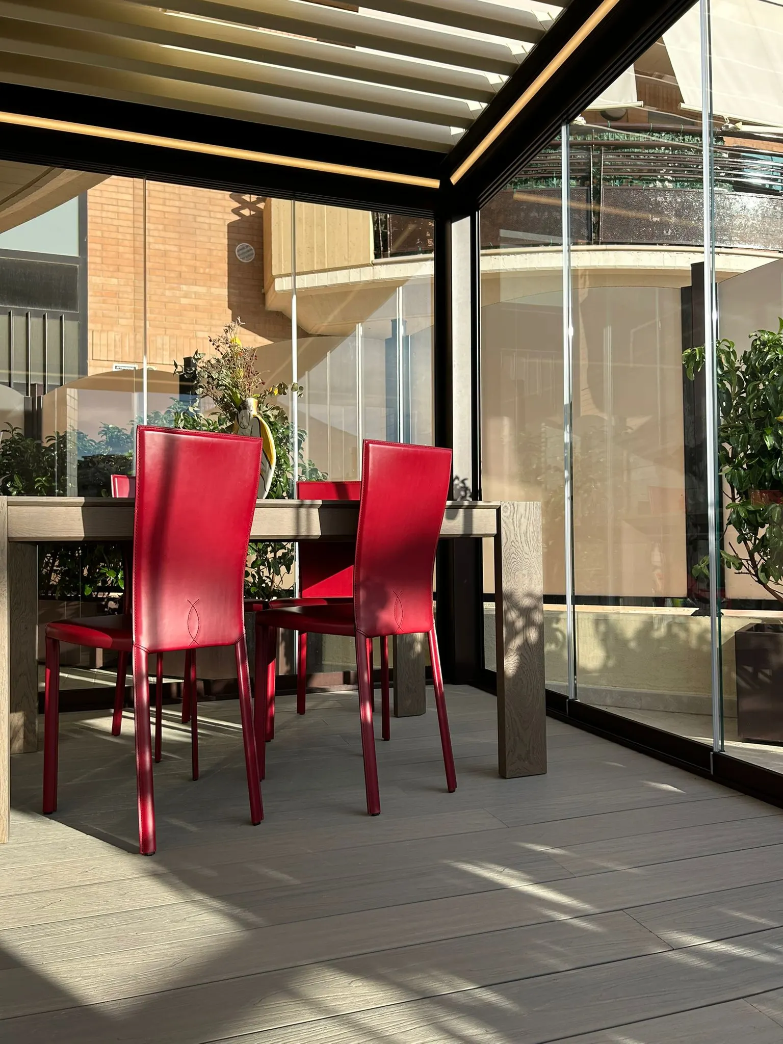 Spazio outdoor contemporaneo con pergola e vetrate